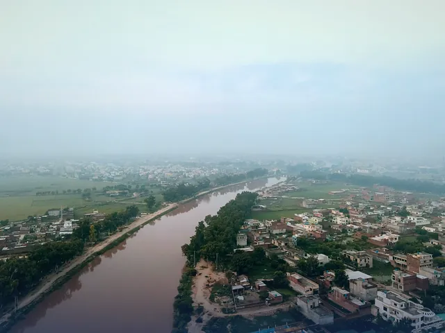 Aerial view of Gujranwala on a misty morning, with water channels running through the city