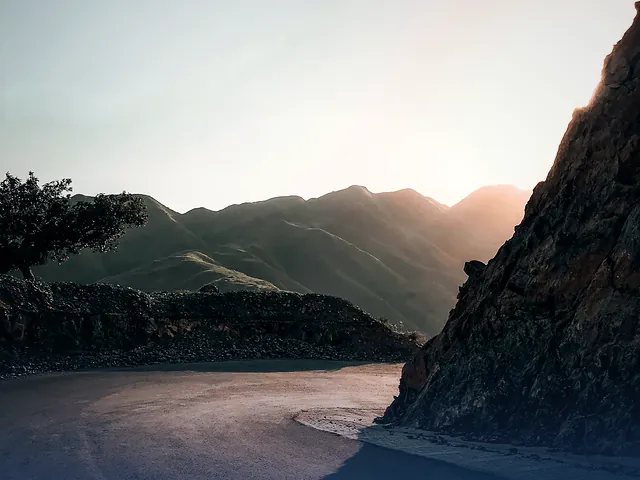 A curving road through the hills of Haripur lit by the setting sun