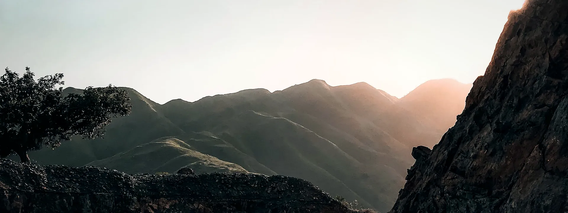 A curving road through the hills of Haripur lit by the setting sun