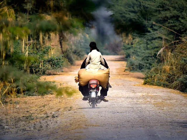 A motorcyclist on a quiet rural road through the Sindh countryside