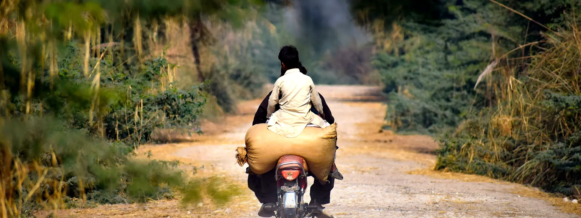 A motorcyclist on a quiet rural road through the Sindh countryside