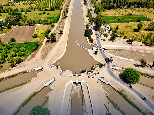 Aerial view of an irrigation canal running through green farmland in Punjab