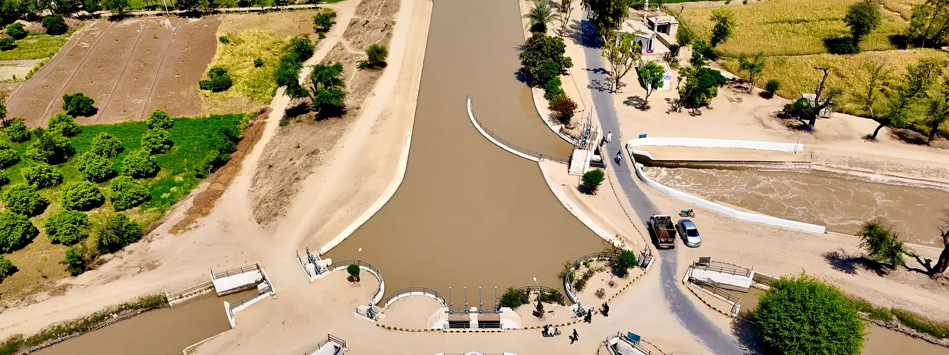 Aerial view of an irrigation canal running through green farmland in Punjab