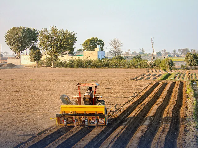 Aerial view of a tractor plowing farm fields in Punjab