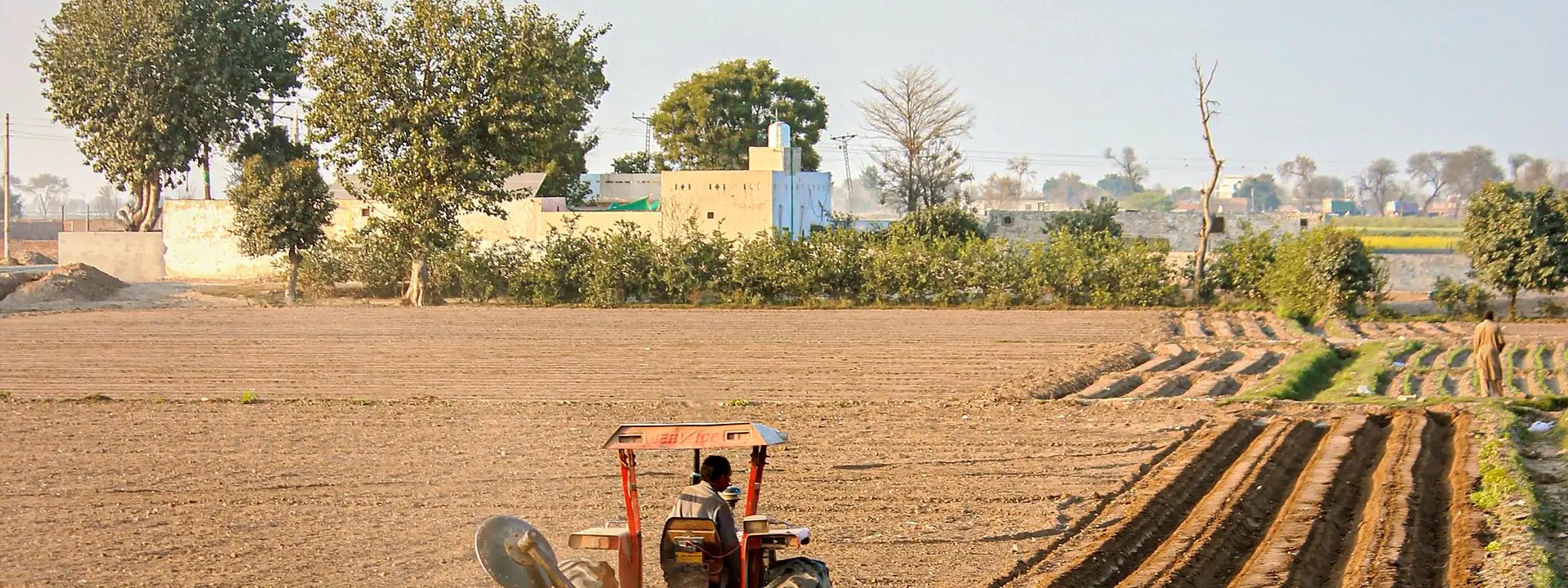 Aerial view of a tractor plowing farm fields in Punjab
