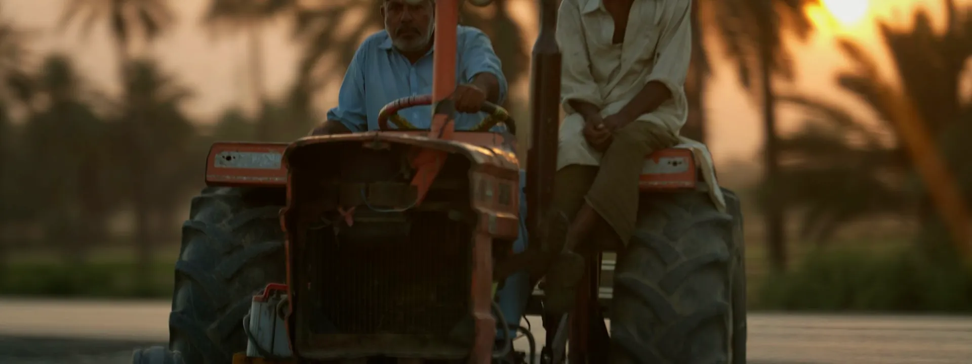 A tractor on a rural road at sunset near Nawabshah