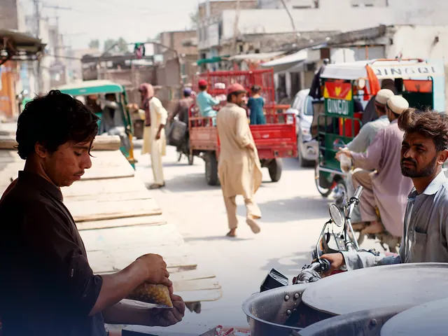 A street food vendor at work on a busy street in Nowshera