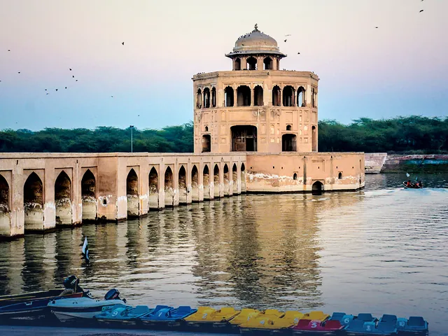 The Hiran Minar pavilion and boats on the water at sunset in Sheikhupura