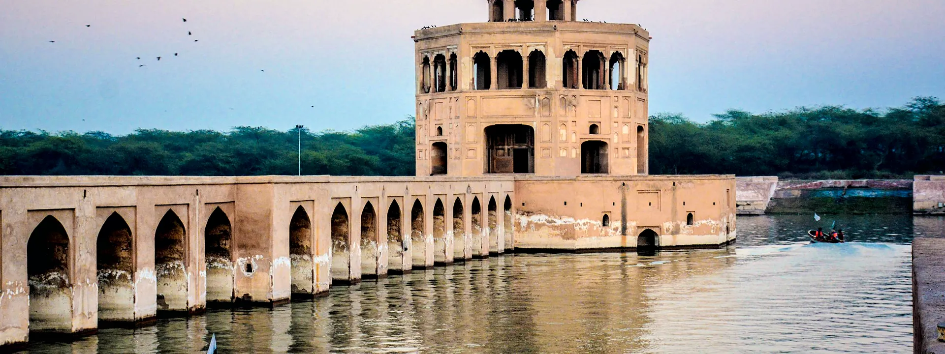 The Hiran Minar pavilion and boats on the water at sunset in Sheikhupura